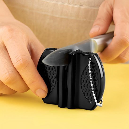 Une femme montre comment utiliser le mini aiguiseur avec un couteau économe en inox