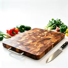 Planche à découper en bois damier transversal avec poignée en acier inoxydable, présentée avec des légumes frais et un couteau de cuisine.