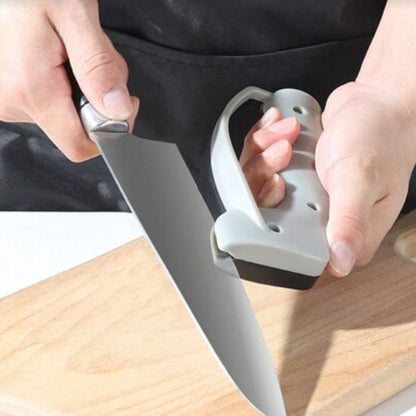 Un homme est en train d'aiguiser un couteau du chef avec une bonne prise en main de son aiguiseur couteau