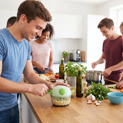 Un étudiant dans une cuisine collective, est en train de hacher de l'ail dans son mini hachoir vert. 