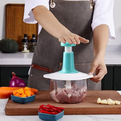 Une femme montre qu'elle hache des cubes de viande dans le hachoir pressoir, dans une cuisine moderne.
