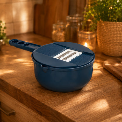Image de la mandoline tout-en-un montrant la mandoline sur son contenant bleu pétrole sur un comptoir en bois dans un décor chaud.