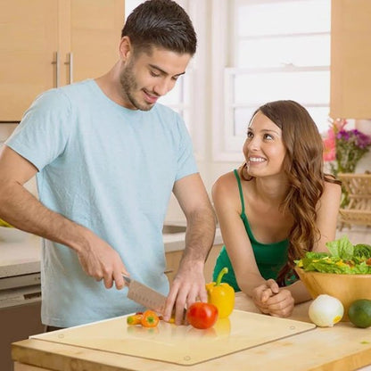 Planche à decouper antibactérienne, montrant un couple heureux. La femme regarde l'homme couper des légumes avec un regard amoureux.