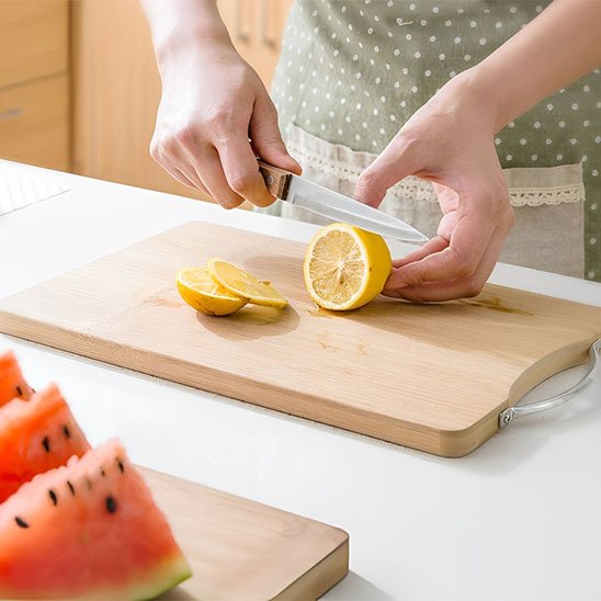 Planche à découper DécoCut utilisée pour trancher un citron frais en cuisine