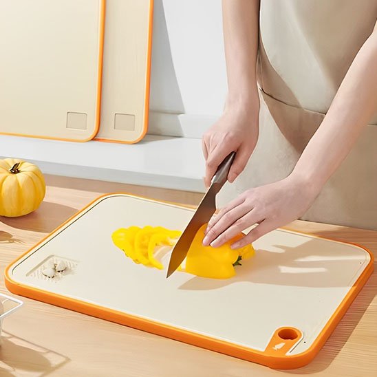 Planche à découper GratedCut en utilisation avec un poivron jaune