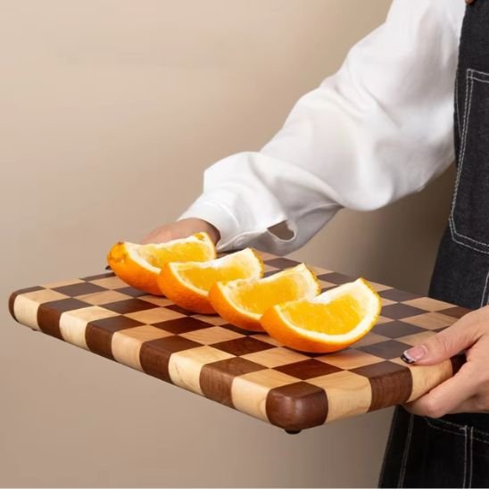 présentation de la petite Planche à découper en bois Damier Premium servant de cabaret pour une orange tranchée