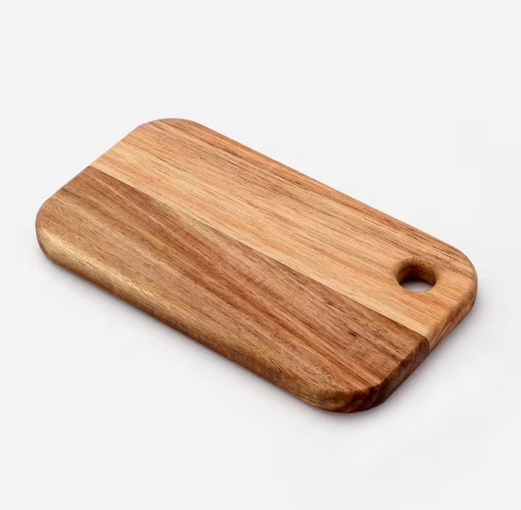 La plus grande des deux petites planches à découper, bois d'acacia avec trou de suspension, vue de face sur fond blanc.
