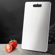 démonstration de la grande planche à découper debout sur un comptoir noir avec une tomate à côté
