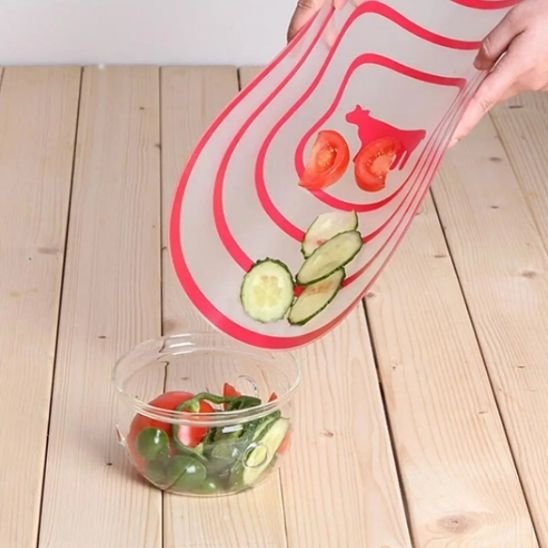 Planche à découper souple, pliée sur la longueur pour verser facilement aliments frais coupés