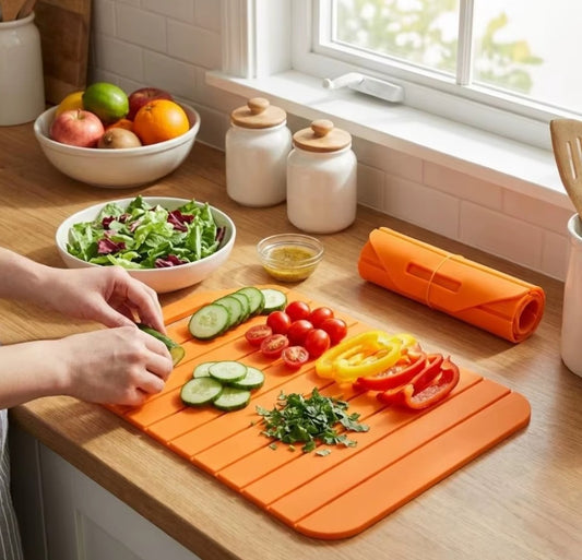 présentation de la planche 
à découper orage en silicone, installée près d'une fenêtre ensoleillée, sur laquelle il y a plusieurs légumes coupés pour  ajouter dans une salade