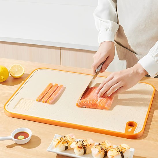 Planche à découper en silicone et paille de blé démontrant une coupe de filet de saumon