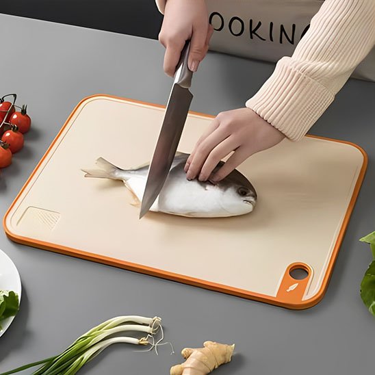 Planche à découper professionnelle démontrant un poisson se faire écailler