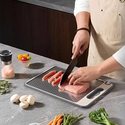 Planche à découper double face, montrant un chef qui tranche une poitrine de poulet du côté inox