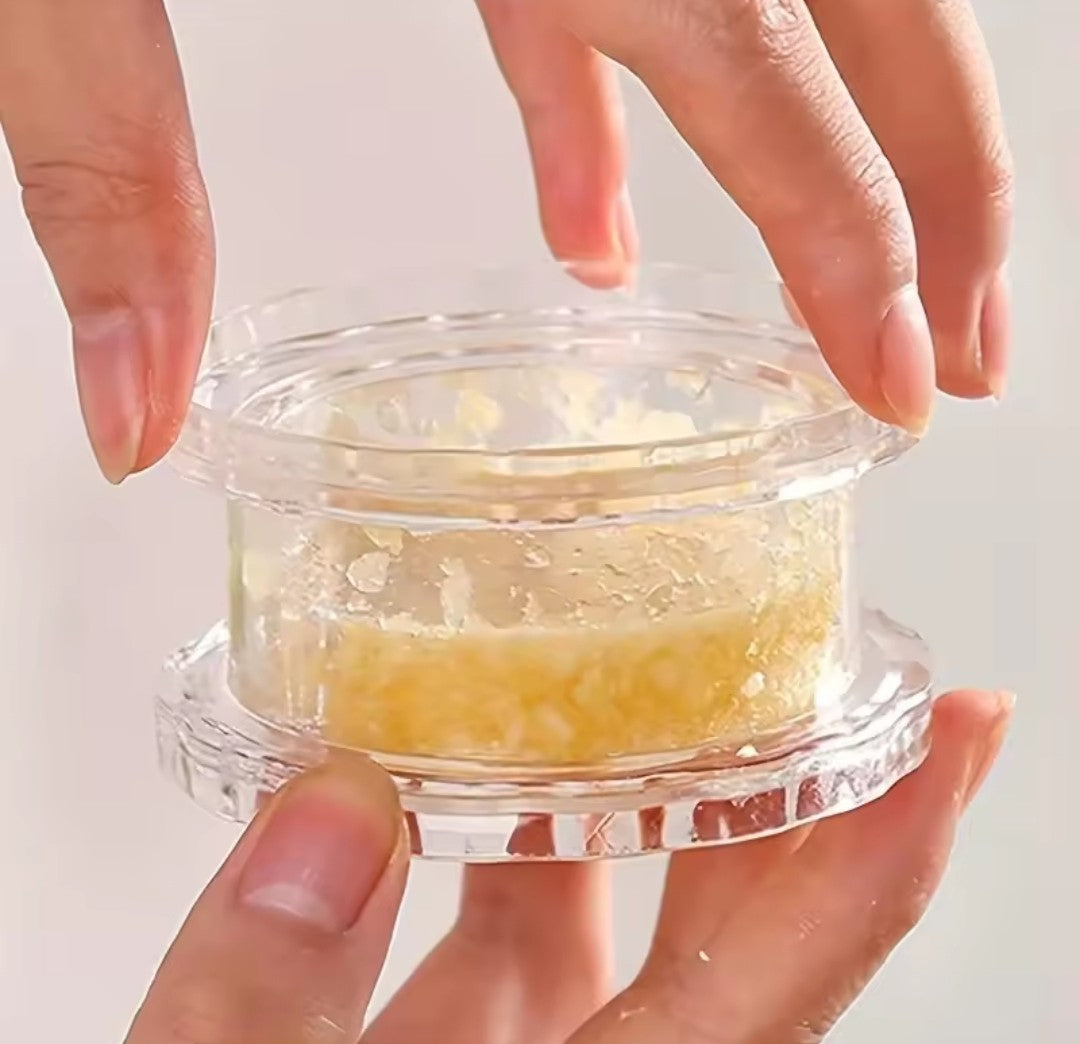 Mini hachoir circulaire à twister clair, présenté du bout des doigts, Sa circonférence de 7.5 cm fait de cet outil, l'un des plus petits et des plus utiles.