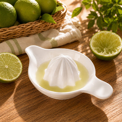 Presse agrumes en céramique blanche dans un joli décor entouré de citrons verts